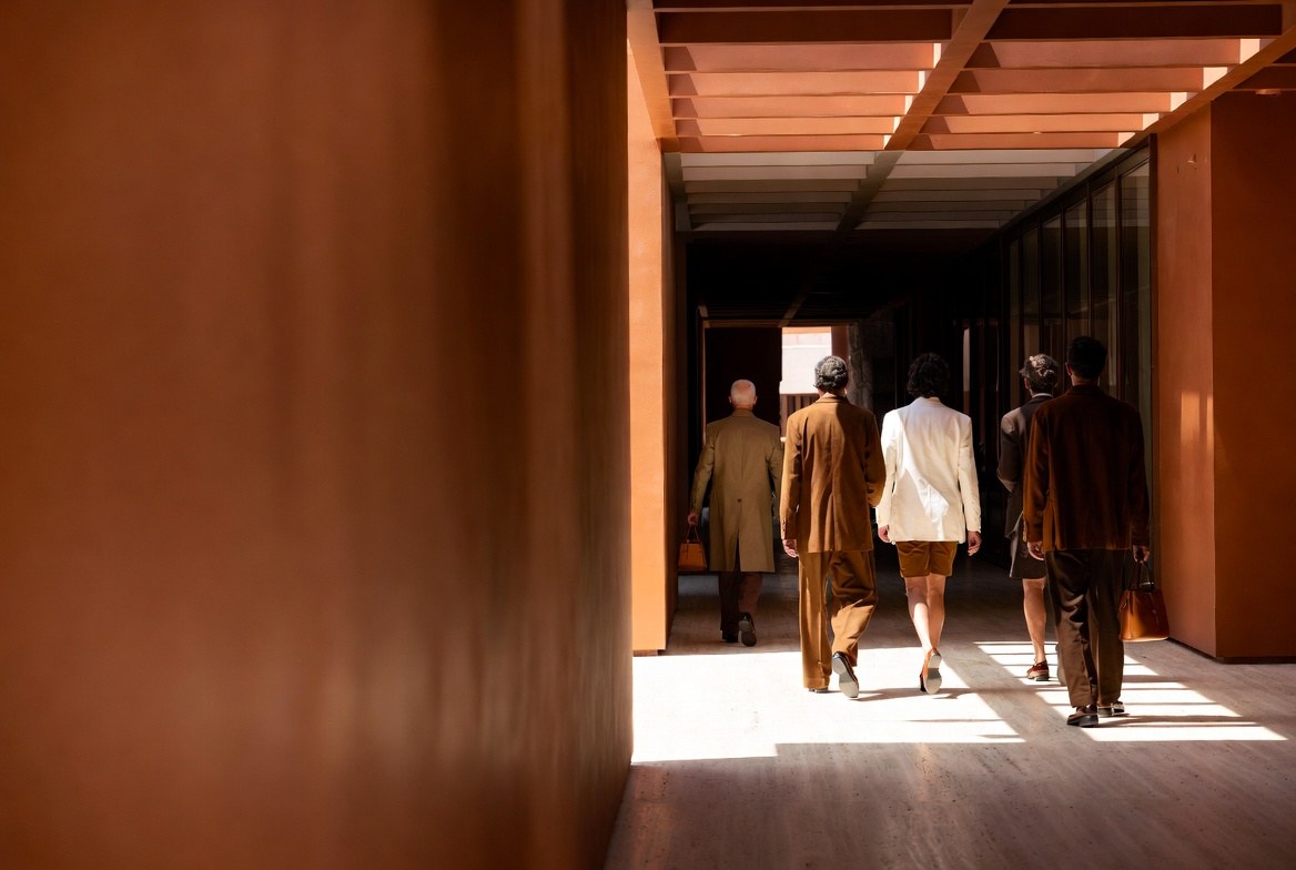 Grupo atravessando um corredor de terracota, à luz do dia